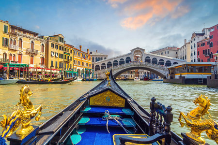 Panoramic view of famous Canal Grande with famous gondola and Rialto Bridge at sunset in Veniceの写真素材