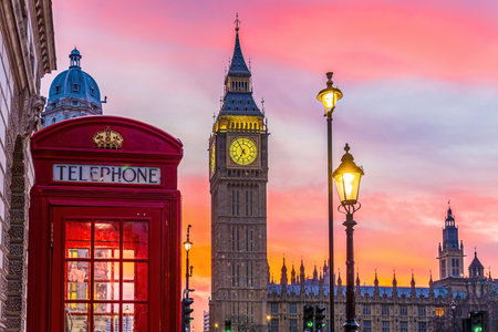 Big Ben tower of Houses of Parliament with telephone booth, Westminster in London, UK at sunrise