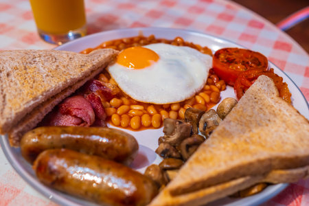 English Breakfast  with fried eggs, sausages, bacon, beans, toasts and tomatosの写真素材
