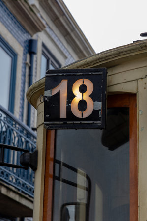 Illuminated number 18 on O Porto Portugal tram with house with typical Portuguese blue ceramic facade Line routeの写真素材