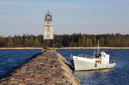 Boat anchored near jetty with coastline in backgroundの写真素材