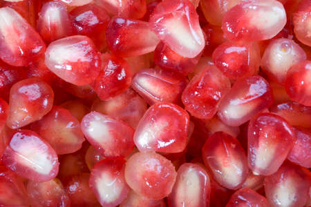 Closeup image pomegranate arils in bulk. Macro on full frame.