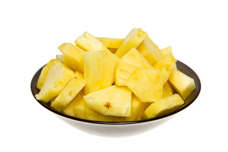A heap of pineapple slice on black plate. Studio isolated on white background.