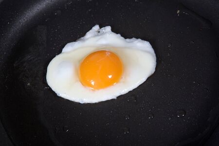 A fried egg in a frying pan の写真素材