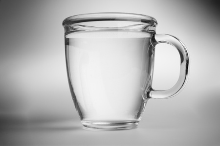 Clear water into a glass mug. Black and white photo.の写真素材
