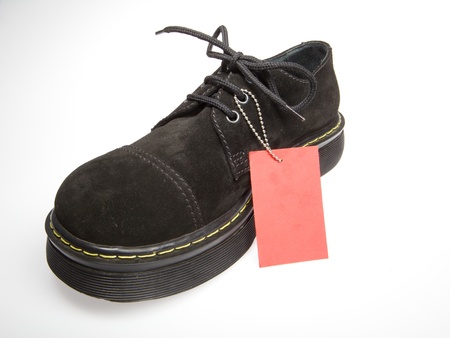 One black men's shoes with empty red label on a white background.の写真素材