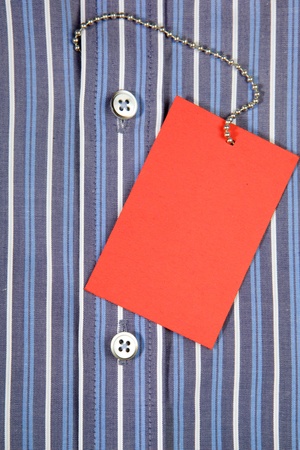 Blue men's shirt and red label on iron ropeの写真素材