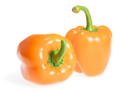 Two orange pepper isolated on white background with shadowの写真素材