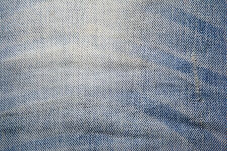 Background of used dark blue jeans with foldsの写真素材
