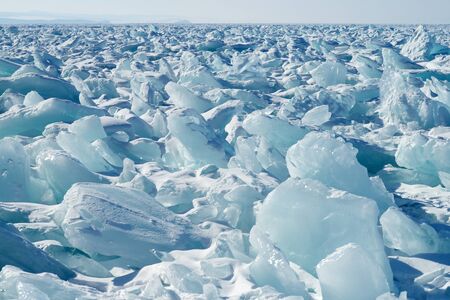 The surface of the frozen lake covered with piles of broken iceの写真素材
