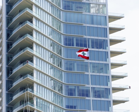 A view of the Beirut Marina tower in Zaitunay Bay in Lebanon and the lebanese flag  A very modern and new construction in Zaitunay bay, changing the waterfront image of Beirut の写真素材