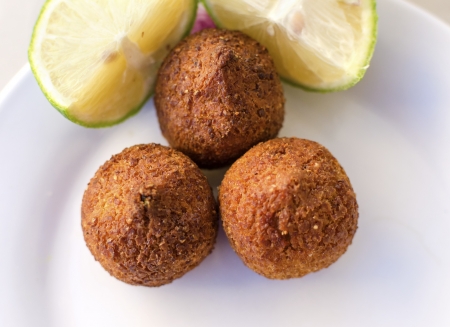 Three small pieces of kebbe, a lebanese dish with mince meat or mushrooms and lemon as viewed from...