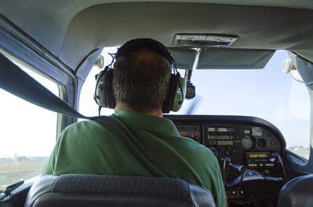 A rear view of a cessna pilot ready for landing. A small airplane with leather seats, with a...