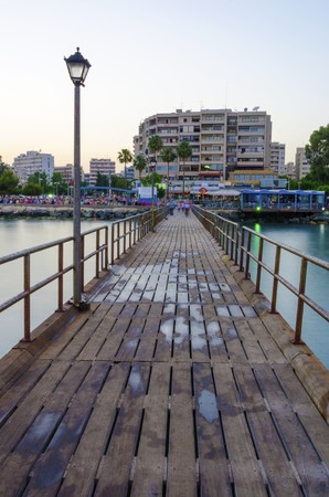 The Limassol pier in Enaerios Area in Cyprus and a view of the town skyline. A day view of the Mediterranean sea, the seaside architecture, blocks of flat, skyscrapers and a couple gazing the view.の写真素材
