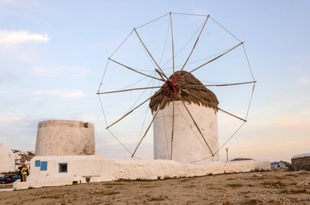 A windmill in Chora, Mykonos, Greece at sunset. Very traditional greek whitewashed architecture, a popular landmark and tourist destination on the island of winds against the deep blue sky and the Aegean sea. The wind mills are now decorative.のeditorial素材