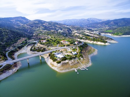 Aerial view of the earthfill dam (aka Embankment Dam) in Yermasoyia, Limassol, Cyprus. A view of the bridge leading to the mountains, the water reservoir, artificial lake and the nature trails in Germasogia area.の写真素材