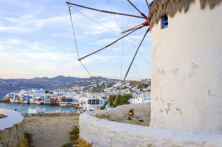 A windmill in Chora, Mykonos, Greece. Very traditional greek whitewashed architecture, a popular landmark and tourist destination on the island of winds against the deep blue sky and the Aegean sea overlooking Little Venice. The wind mills are now decoratの写真素材