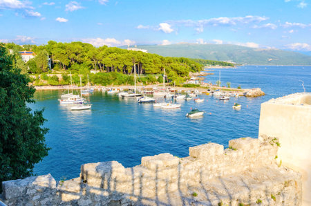The interior of the Frankopan Castle, at Kamplin square in Krk town, Croatia - Frankopanski Kastel, part of the medieval city walls. View of the archer loop holes and sea port of the island with boats dockedのeditorial素材