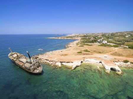 Aerial view of the abandoned ship wreck EDRO III in Pegeia, Paphos, Cyprus. The rusty shipwreck is stranded on the Peyia rocks at the kantarkastoi sea caves near Coral Bay in Pafos, standing at an angle near the shore.の写真素材