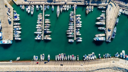 Aerial bird's eye view of Latchi port, Akamas peninsula, Polis Chrysochous, Paphos, Cyprus. The Latsi harbour with boats and yachts aligned, fish restaurants, promenade, beach tourist area from above.の写真素材