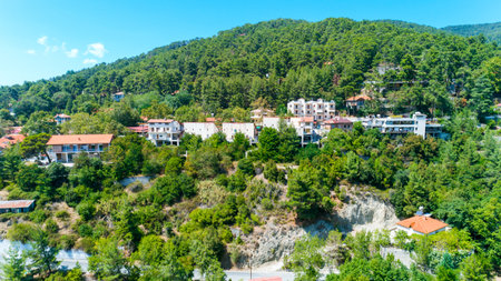 Aerial view of Pano Platres village,winter resort, on Troodos mountains, Limassol, Cyprus. Bird's eye view of pine tree forest, red roof tiled houses, hotels, panagias faneromenis church from above.のeditorial素材