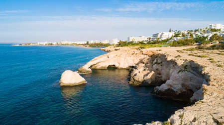 Aerial view of coastline and landmark Love bridge and sea caves, at Cavo Greco, Ayia Napa, Famagusta, Cyprus from above. Bird's eye view of tourist attraction cliff rock natural formation rocky arch in Ammochostos from above.の写真素材