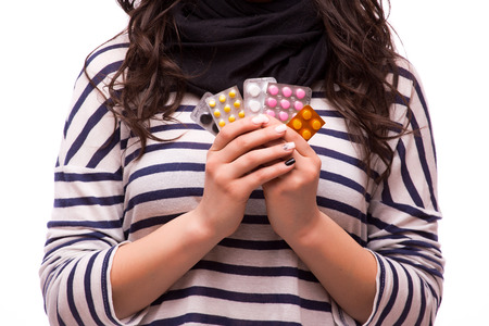 beautiful girl showing many differents medicines tablets on whiteの写真素材