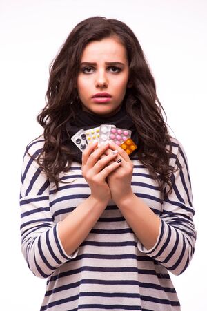 beautiful girl showing many differents medicines tablets on whiteの写真素材