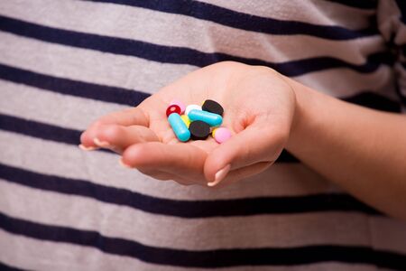 Pills, tablets, vitamins and drugs heap in woman hands, closeup view.の写真素材