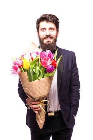 Handsome bearded man wearing in suit, with beard and nice bouquet of flowers against white backgroundの写真素材