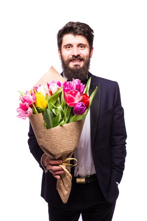 Handsome young man wearing in suit, with beard and nice bouquet of flowers against white backgroundの写真素材