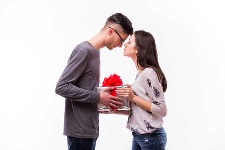 Young hipster Man Giving a Gift on holiday his girlfriend. She want kiss him. Caucasian couple against white background.の写真素材