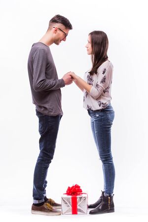 Happy young hipster couple with present isolated on a white background. Happy man giving a gift to his girlfriend. Holiday.の写真素材
