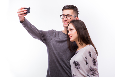 Happy hipster couple taking a selfie on white backgroundの写真素材
