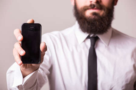 young bearded man pointet phone on whiteの写真素材
