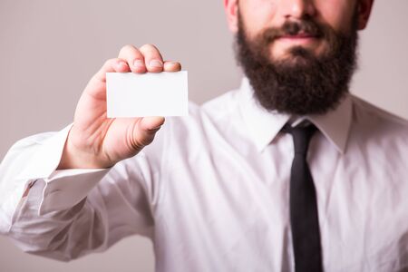 Bearded man  holding and pointing blank cardの写真素材