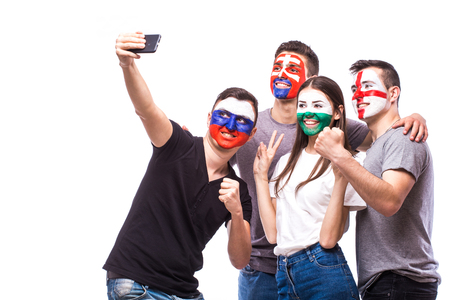 Group of football fans their national team: Slovakia, Wales, Russia, England take selfie photo on white background. European football fans concept.の写真素材