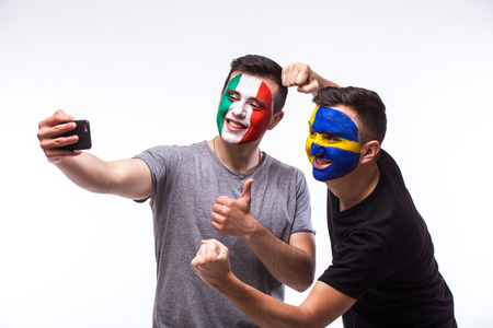 Italy vs Sweden football fans take selfie photo with phone on white background. European football fans concept.の写真素材