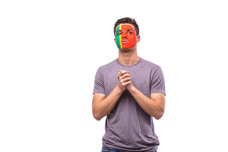 Pray for Portugal. Portuguese football fan pray for game Portugal national team on white background. European football fans concept.の写真素材