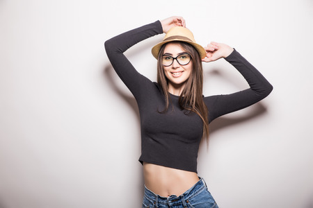 Portrait of beautiful young woman in glasses and funky hat over white backgroundの写真素材