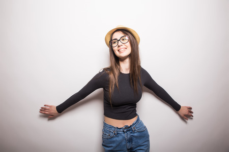 Portrait of beautiful young woman in glasses and funky hat over white backgroundの写真素材