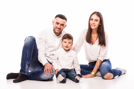 happy family mother, father and son sitting on the floor on whiteの写真素材
