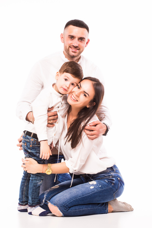 happy family mother, father and son sitting on the floor on whiteの写真素材