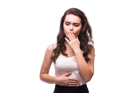 Closeup portrait of young unhappy, annoyed, sick woman about to chuck, throw up, retch barf, hurl isolated on white background.の写真素材