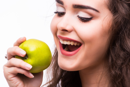 Young girl  eat apple. Female teeth  and apple. Healthy eating on white backgroundの写真素材