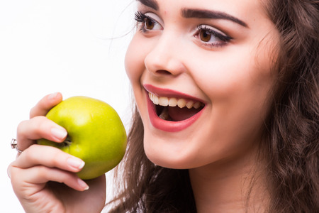 Young girl  eat apple. Female teeth  and apple. Healthy eating on white backgroundの写真素材