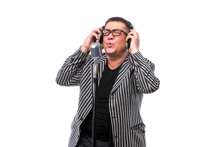 Showman concept. Singer listening music and sing in microphone on white backgroundの写真素材