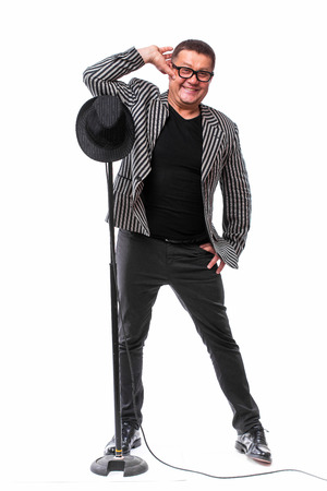 Charismatic handsome man in suit with black hat and microphone possing on white backgroundの写真素材