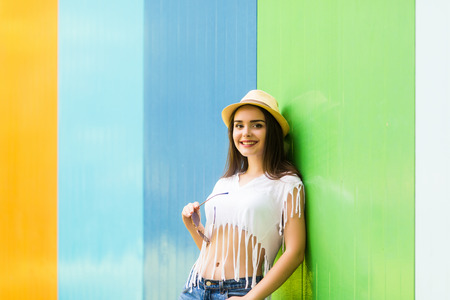 Outside portrait of pretty woman  in sunglasses and hat over color backgroundの写真素材