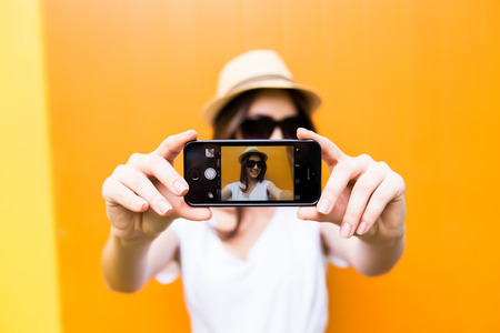 Hipster cool girl taking picture on smartphone self-portrait, screen viewの写真素材